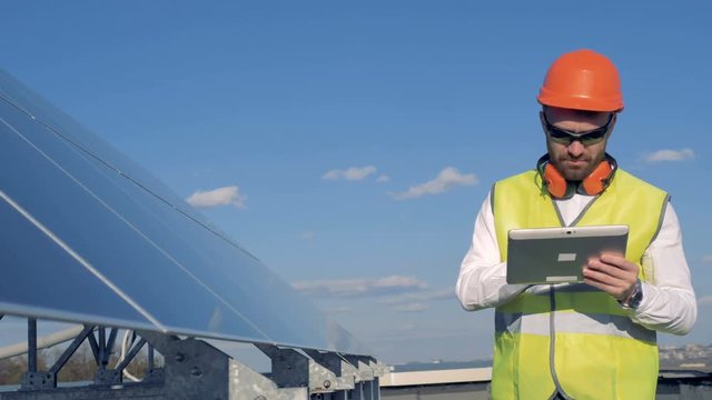 Worker looks at solar panels.