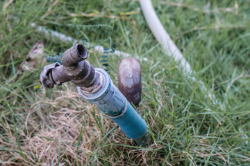Water faucet with grass at outdoor house., texture background