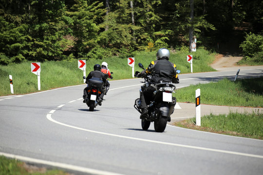 Fototapeta Gruppe von Motorradfahrern auf einer kurvenreichen Landstraße  