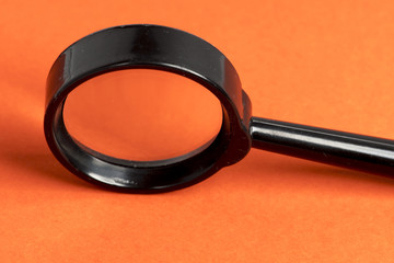 Magnifying glass on orange background