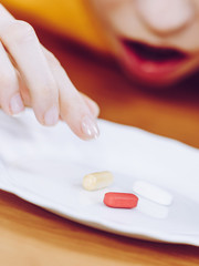 Shocked woman having pills on plate