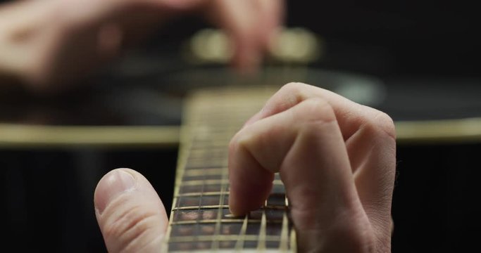 Fingers plating on the fretboard of a guitar