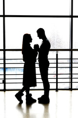 silhouette of a couple on a window background. holding hands. love, confession, offer.