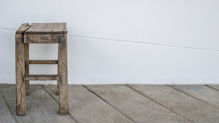 Old wooden chair near white wall., with copy space for text.
