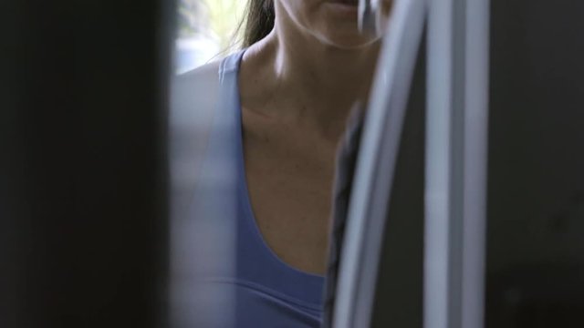 Fit young woman working out at the gym and performing triceps pushdown exercise with v-bar attachment
