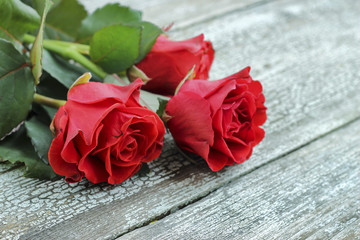 Naklejka premium Red roses on a wooden background