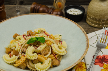 Fried swordfish cubes with fresh vegetables and pasta salad. Fresh salad with fish. Concept healthy food.