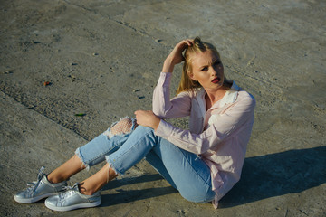 Fototapeta premium Woman sit on cement ground, fashion.