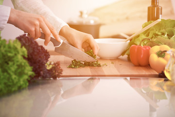 Close Up of human hands cooking vegetable salad in kitchen on the glass table with reflection. Healthy meal, and vegetarian food concept