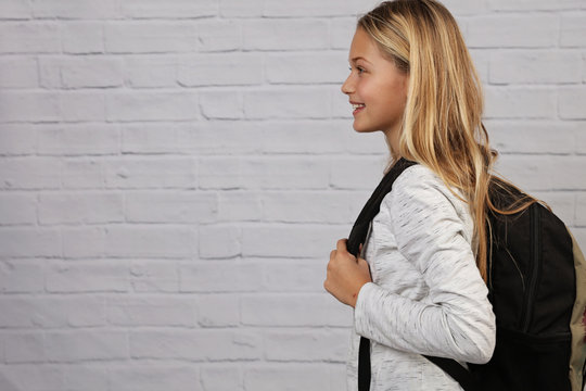 Portrait of happy smiling school girl wearing backpack. Good posture concept.