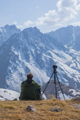 photographer traveler takes a mountain landscape,a camera on a tripod