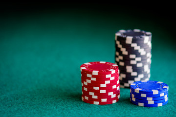 casino chips of different colors on green felt table