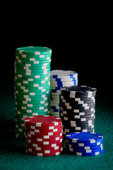 casino chips of different colors on green felt table