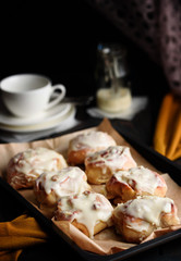 Sweet buns with a block and cinnamon on a dark background