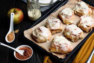Sweet buns with a block and cinnamon on a dark background