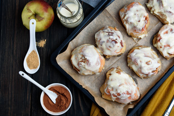 Sweet buns with a block and cinnamon on a dark background
