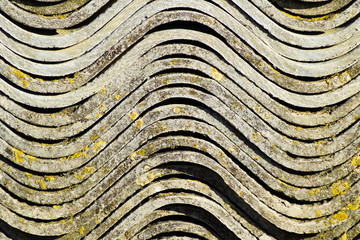 Corrugated slate lies in a pile, side view background texture of slate.
