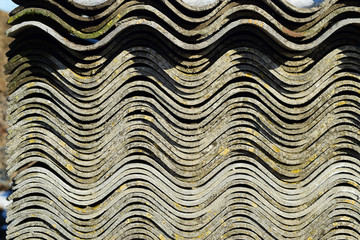 Corrugated slate lies in a pile, side view background texture of slate