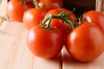 Close-up of fresh, ripe tomatoes on wooden background.