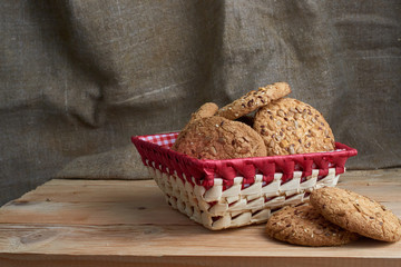 Savory cookies sprinkled with sesame seeds, sunflower on table and burlap background
