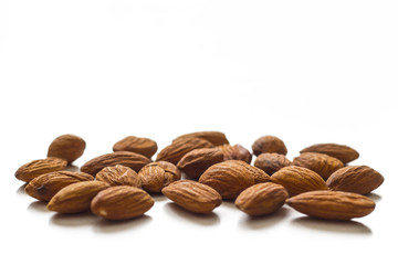 A handful of almonds on the table. Isolated over white background