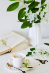 Vase with White Flowers Bird Cherry Tree, Morning, Cup with Coffee, Old Book, Spring Time, Summer Concept, White Background, Copy Space