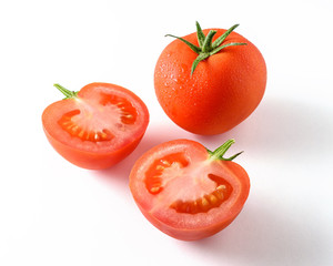 Whole tomato and a half tomato isolated on white.