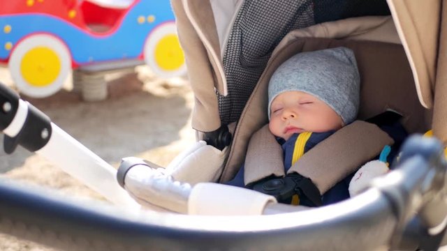 Sweet little baby boy sleeping in stroller