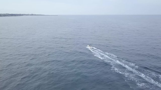 Aerial of a fast luxury speed boat racing in blue sea waters
