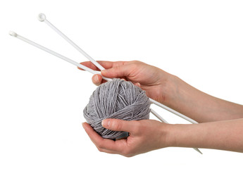 Obraz premium Ball of soft gray yarn and knitting needles in woman hands isolated on white