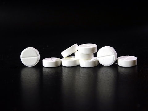 White pills close-up on dark