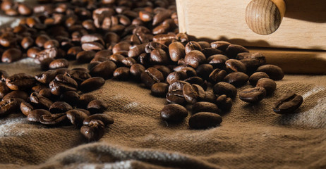 Fragment old Coffee grinder on Burlap fabric. Scattering of coffee beans.