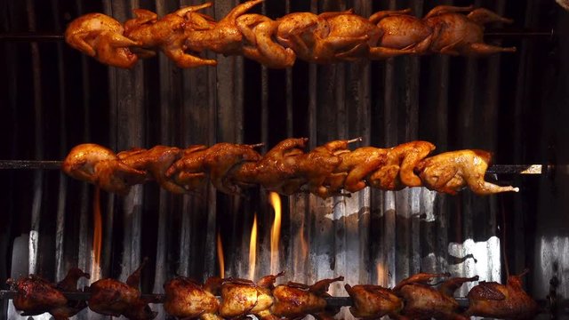 Grilled chicken grills on a spit rotate over fire. HD video