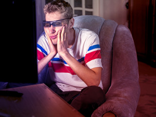 portrait of bored  young man watching film in 3d glasses