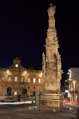 Fototapeta na wymiar Italy, SE Italy. Ostuni. Statue of Saint Oronzo looks down on the square of Italian town of Ostuni which is known as the 'White City' in Italy. Night view.