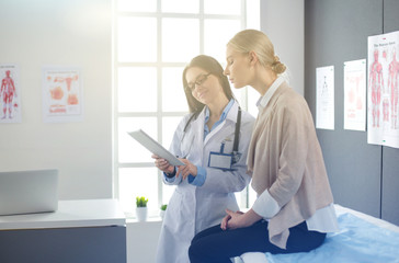 Doctor and patient discussing something while sitting at the table . Medicine and health care...