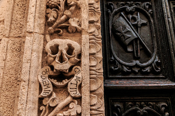 Italy, SE Italy,  province of Bari, region of Apulia, Monopoli. Roman Catholic church entrance. Door and arch detail. Skull. Latin reads 