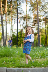 little brother and the sister sit on a glade with fluffy white dandelions