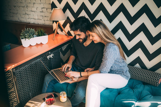 Young Couple Sitting On Sofa, Shopping Online