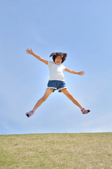 青空でジャンプする女の子