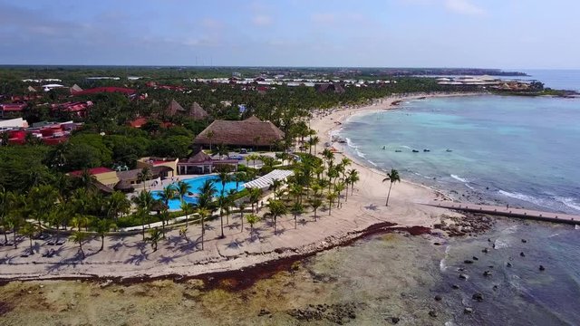 Aerial drone shot. Aerial view from above, birde eye view at an luxury resort hotel beach of a tropical coast. Turquoise water of the Caribbean Sea. Riviera Maya Mexico.