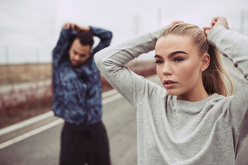 Fototapeta premium Young couple stretching together before an outdoor run