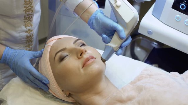 Therapist makes rf-lifting procedure of facial skin
