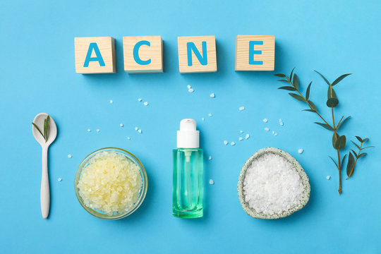 Cubes with word "Acne" and ingredients for homemade problem skin remedy on color background