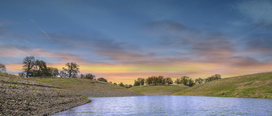 View from on the lake of colorful sky and surrounding hills