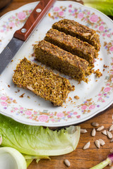 Raw vegan flax bread slices with wheat sprouts and sunflower seeds. On plate served for lunch and good with fresh vegetables. Vegetarian healthy food
