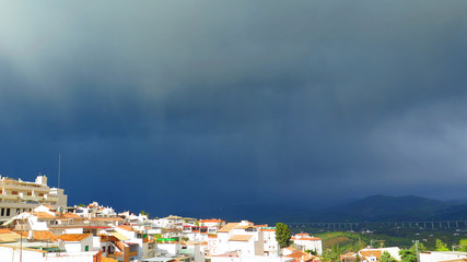 Fototapeta premium Dark rain clouds approaching village