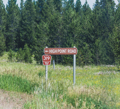 Sign in forest labeled "High Point Road" in Montana mountains.