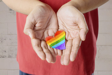 Anonymous man holding heart with rainbow color