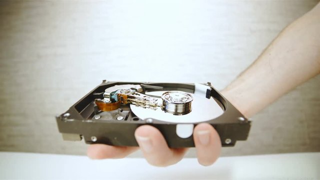 Holding a opened hard disk drive close up 4K